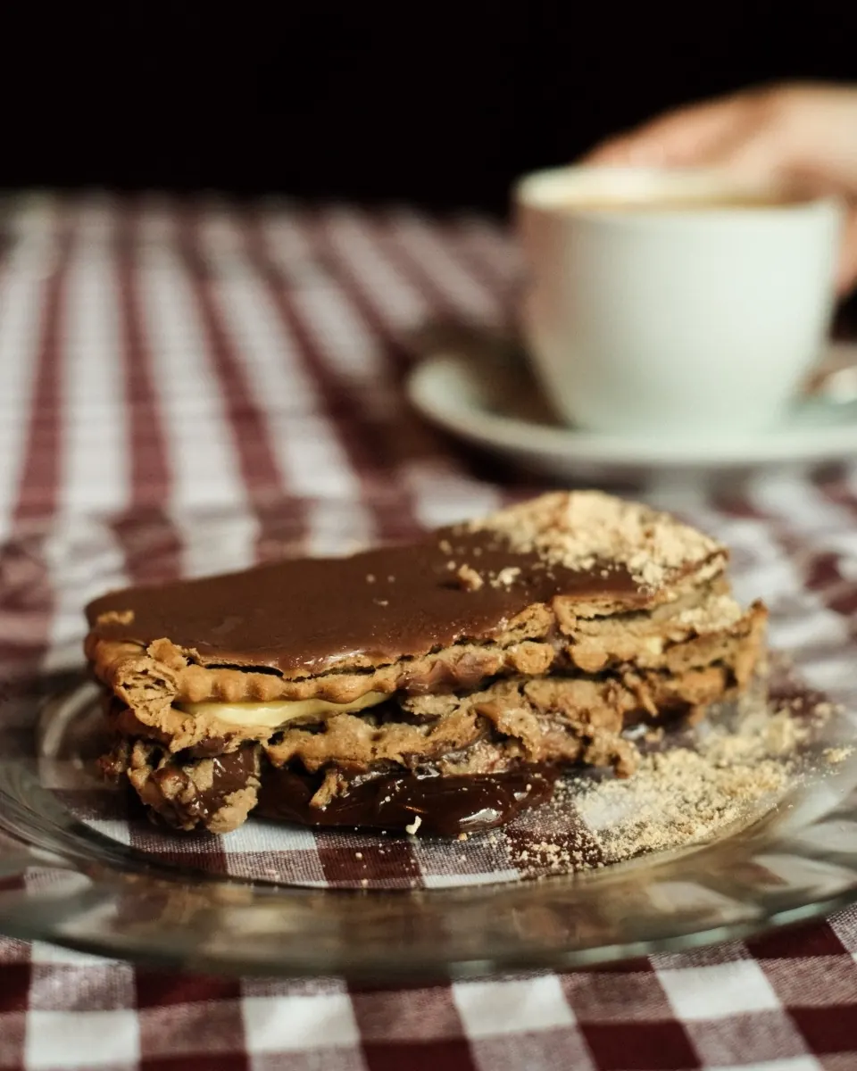 Postre de hojaldre con crema de chocolate sobre mantel de cuadros